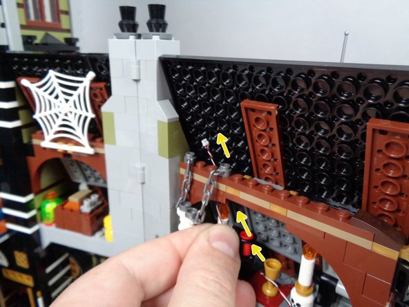 As shown by the yellow arrows in the third photo for this step, continue feeding the control wire up and BEHIND the attic wall section.