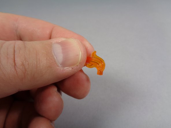 Your Brickstuff kit includes four transparent orange LEGO flames with the pins cut off.  As shown in the second and third photos, take these flames and use them along with the round transparent orange plate to replace the flames on top of each candle.