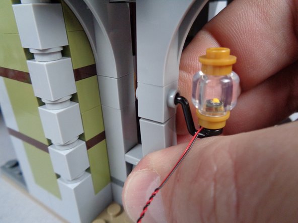 As shown in the photos for this step, mount the second front porch light and begin routing its wire using the same techniques you used for the first porch light.