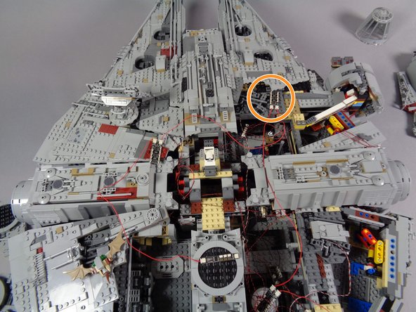 As shown by the orange circles in the first and second photos for this step, position the second BRANCH09X adapter board on top of the front section of the Falcon.