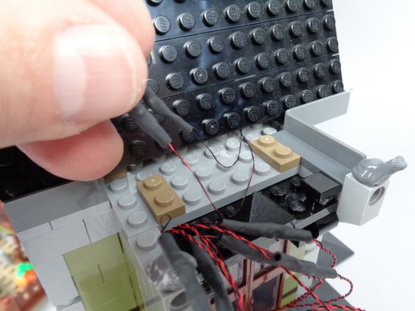 As shown in the second photo for this step, pull the two light wires out the front of the roof.