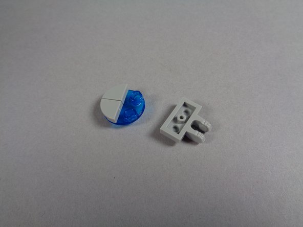 As shown in the first photo for this step, continue disassembling the first blue light by separating the 1x2 light bluish gray plate with clip.