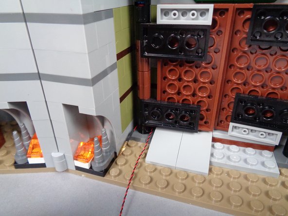 As shown by the blue arrow in the first photo for this step, feed the plug end of the wire behind the left front door's hinge.