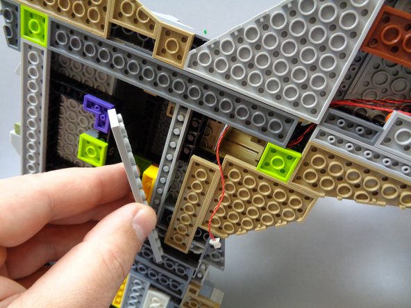 As shown in the second photo, remove the large light bluish gray plate below the dark bluish gray plate that the red wire passes over.
