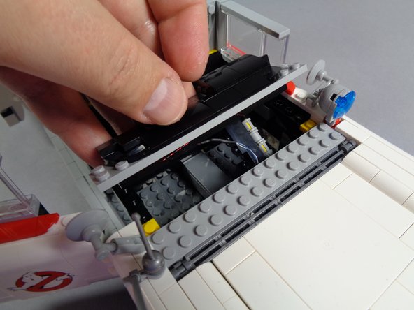 As shown in the first photo for this step, carefully re-attach the dashboard section, including the light bluish gray plate under the dashboard.