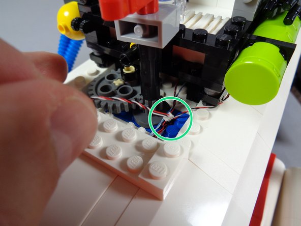 Take the rear lightbar wire (first photo) and pass it down through the same hole as the wire for the front lightbar, as shown by the green circle in the second photo.