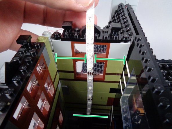 As shown in the photo for this step, repeat the process with the second light strip on the opposite tower wall.