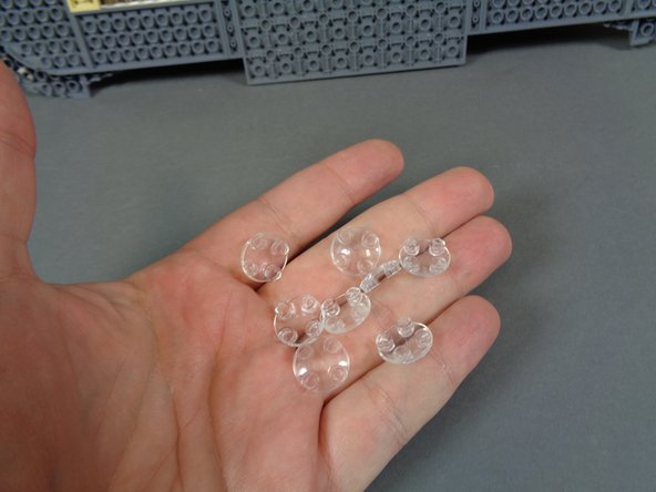 Begin by taking the eight round &quot;boat stud&quot; parts out of the bag as shown in the second photo.