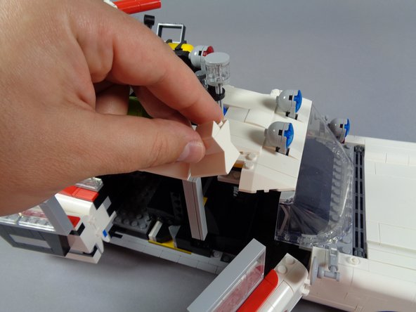 As shown in the first and second photos for this step, finish re-attaching any other parts to the roof that may have come off during disassembly.