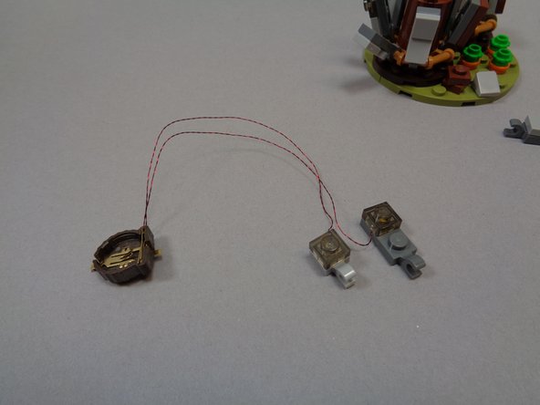 Insert a battery into the battery holder.  You should see both lights come on as shown in the third photo.