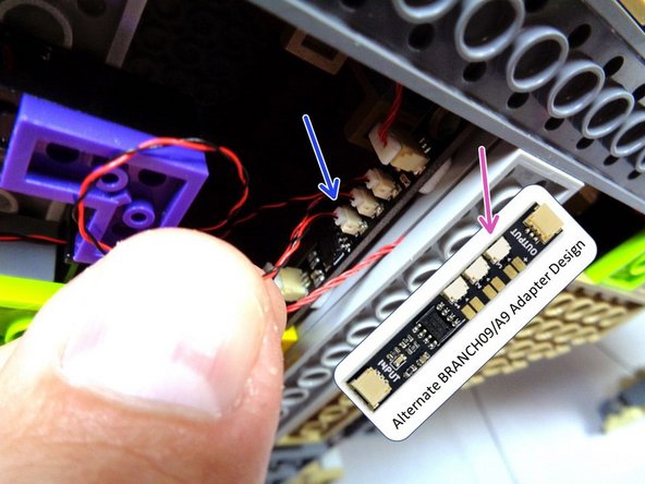 If your BRANCH09 adapter board has top-facing connectors, connect the cauldron light power wire to the last open plug on the BRANCH09 adapter as shown by the blue arrow in the second photo.  All five plugs on the BRANCH09 adapter board should now be full.