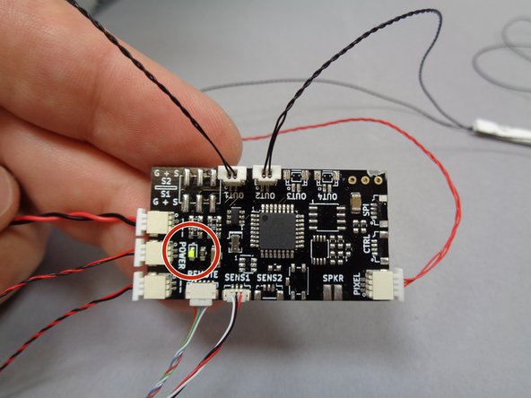 Connect the USB cable to a power source.  As shown by the red circle in the third photo, the green power light on the TRUNK08 master controller should turn on.