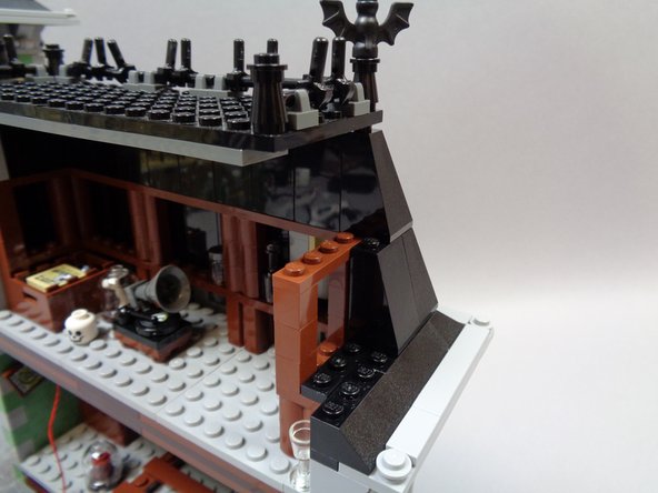 As shown in the third photo, begin removing black roof slope pieces from the rear attic roof to make room for running wires.