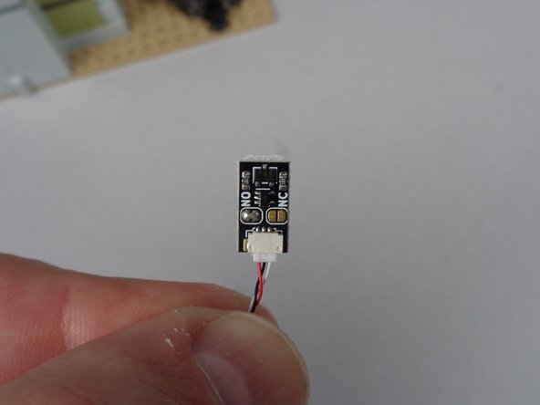 The first photo for this step shows the magnetic switch.  It should already have a long 3-wire connecting cable attached as shown.