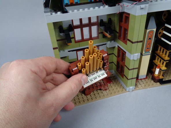 As shown in the first photo for this step, remove the organ from the front room.