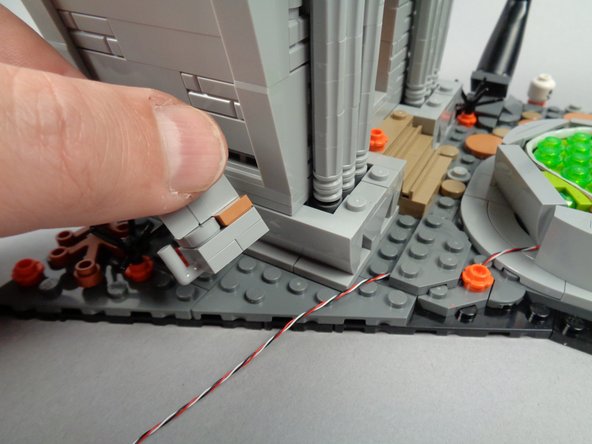 As shown in the first photo for this step, remove the section with the bracket next to the town hall.