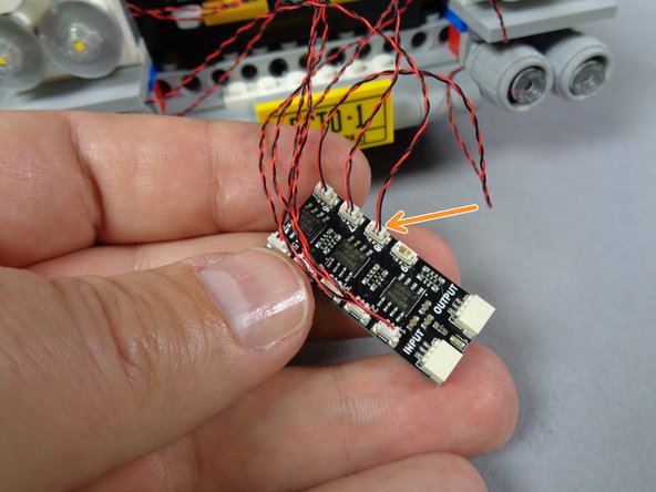 As shown in the first photo for this step, re-attach the fourth lower headlight.