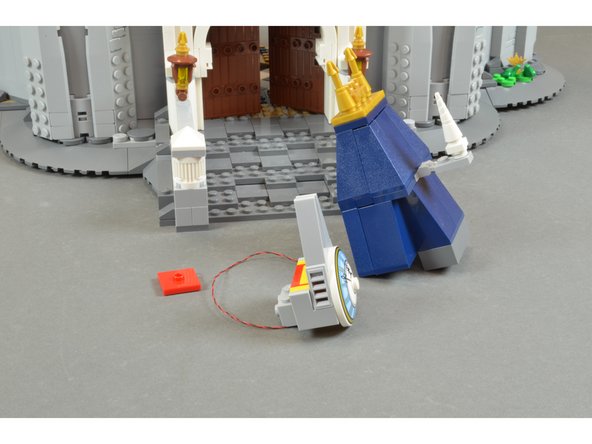 As shown in the first photo, re-mount the clock face into the roof section, routing the LED light wire under the yellow LEGO brick.