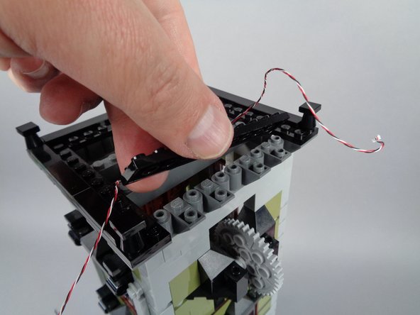 The photos show the top elevator gear without its chain, but you will have already reconnected your elevator chain in the previous step.