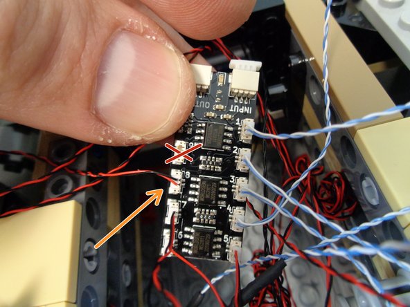 As shown by the dotted blue line in the second photo, route the door frame light wire into the left-side docking back area where the third BRANCH09X board is located.
