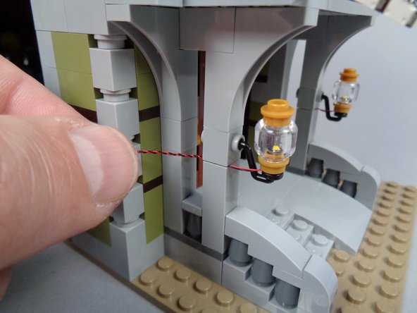 As shown in the photos for this step, mount the second front porch light and begin routing its wire using the same techniques you used for the first porch light.