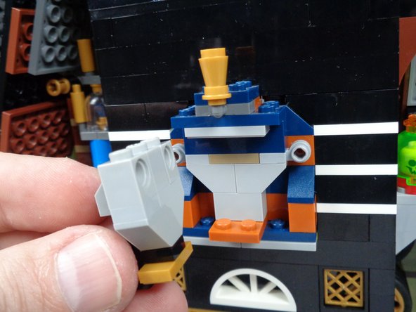 As show in the photos for this step, press upward on the top of the pharaoh's headgear to make room to remove the face parts.