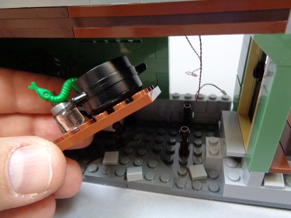 As shown in the photos for this step, remove the kitchen table and stove assembly.  Open the oven-- this is where you will mount the last orange light in the next step.