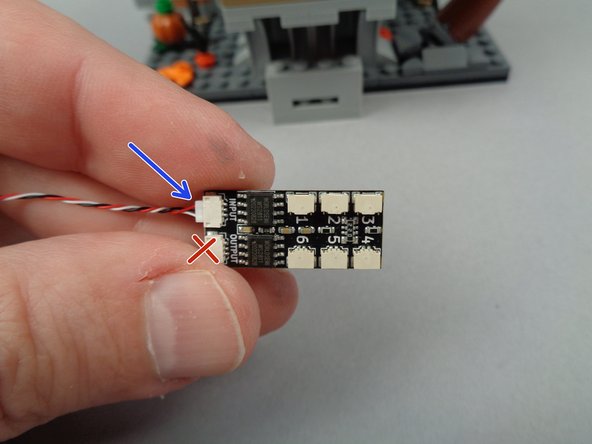 As shown by the arrow in the second photo for this step, connect one end of the 3-wire cable to the INPUT plug of the BRANCH06X driver board.