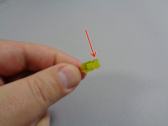 As shown by the red arrow in the first photo, attach the transparent yellow round 1x1 plate from your LEGO® set to the top of the transparent yellow LED brick with the Pico LED light inside.