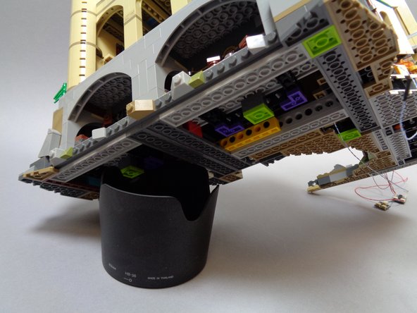 You may find it helpful to prop your castle up on something while you work, as shown in the second photo.  (here we used a camera lens hood, but you can use any similarly-sized object to hold up your castle)