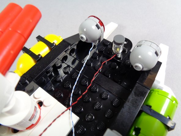 As shown in the second photo for this step, carefully press the transparent round brick down on top of the cool white Pico LED light.