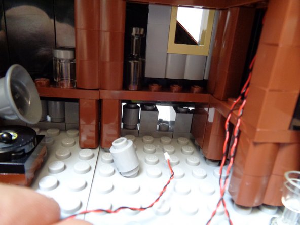 As shown in the second and third photo, route the two attic light wires through the gap and out the back of the roof.