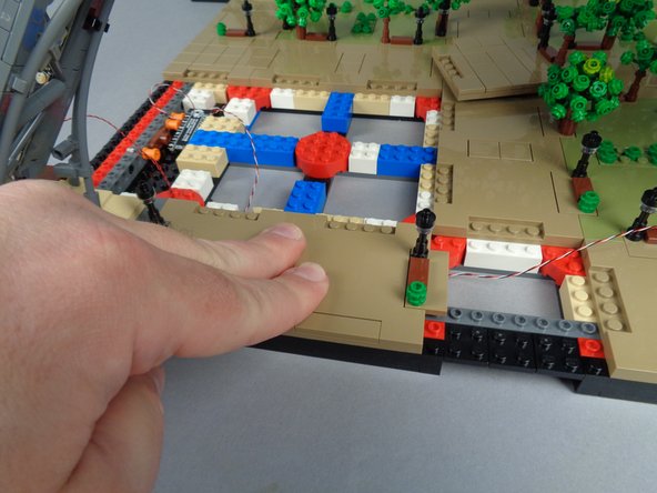 As shown in the third photo for this step, press down to firmly re-attach Panel 2R.