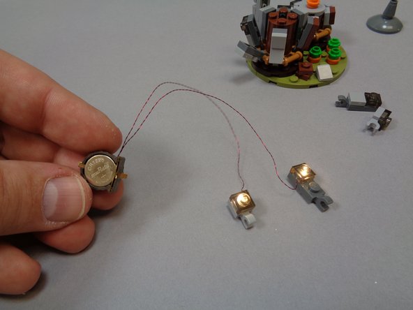 Insert a battery into the battery holder.  You should see both lights come on as shown in the third photo.