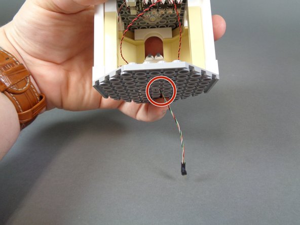 The red circles in the second and third photos show the hole through which the wire passes.
