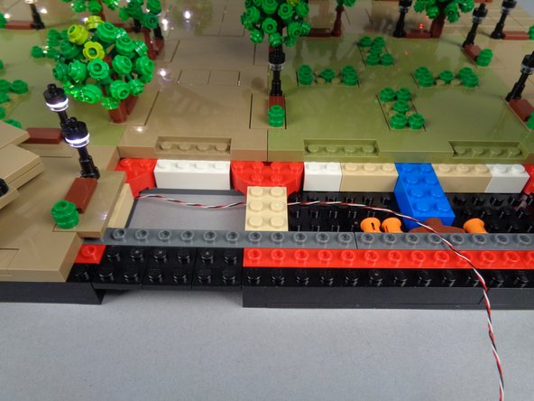 As shown in the third photo, you should now have the control cable passing from Sections 1 and 2 (the lamp posts you have already connected) over to Section 3 (where you will work next).