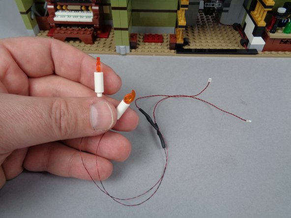 As shown in the first photo for this step, inside your BOX #2, there will be two pre-lit candles in a small pink bag.