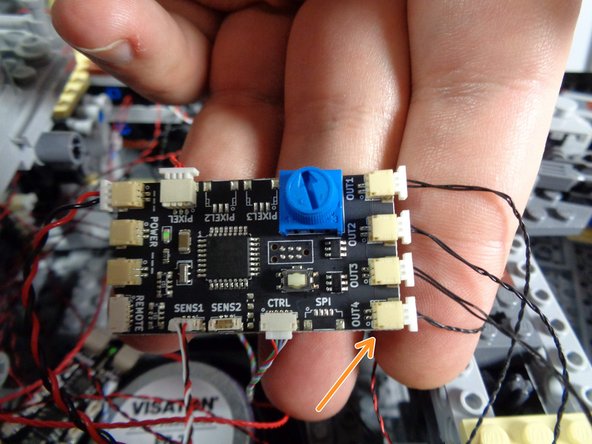 As shown by the orange arrow in the third photo, connect the other end of the spare black wire to the bottom right plug on the new TRUNK08 controller.  This plug is labeled OUT4.