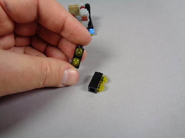 As shown in the second and third photos for this step, remove the four black 1x1 bricks from the front sides of the marquee, and remove the four transparent yellow round 1x1 plates from the bricks.