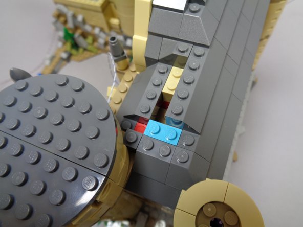 As shown in the third photo (red circle), make sure to remove the light blue 1x2 brick.  You will use this later in another location.