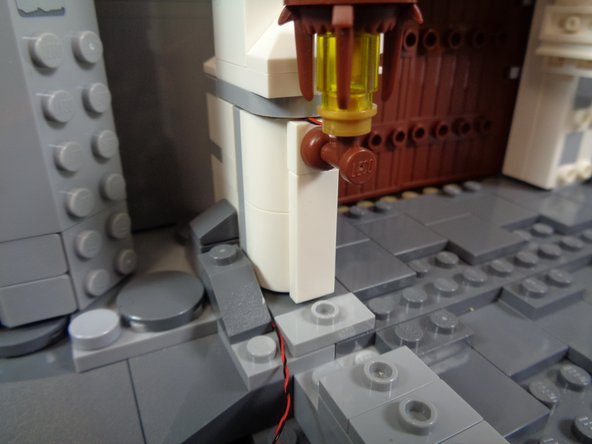 As shown in the photos for this step, begin carefully re-attaching the rock pieces you removed earlier.