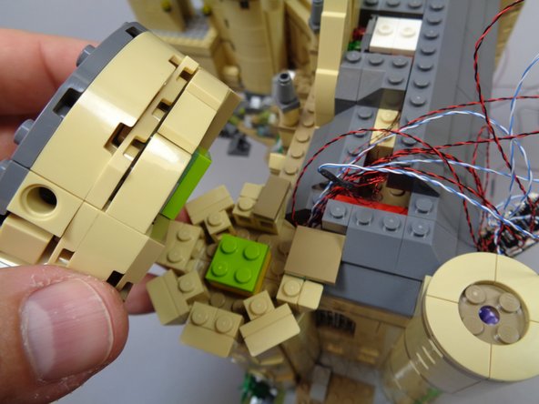 As shown in the photos for this step, carefully re-attach the larger tower top section.