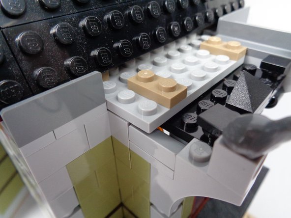 Finally, as shown in the third photo for this step, replace the 1x2 LEGO brick you removed in the previous step with the plate/slope assembly.