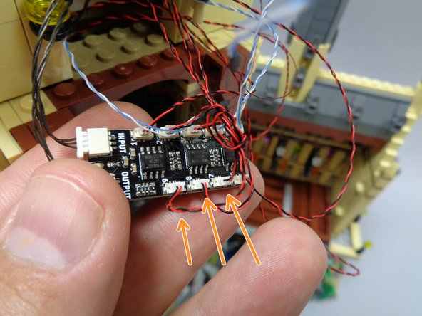 As shown by the three orange arrows in the second photo, connect the three rooftop tower lights to plugs #7, #8, and #9 on the BRANCH09X adapter board.  These wires should be tied together in a knot, making them easy to identify.