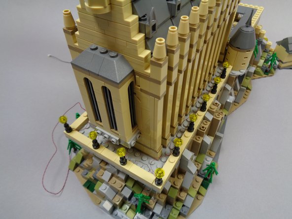 As shown in the second photo, all wires should exit toward the rear of each lamp post.  Wires should not be visible from the front.