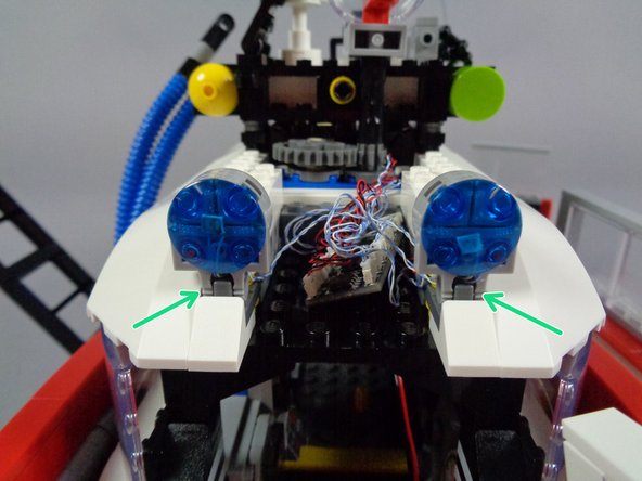 As shown by the two red circles in the first photo, position the adapter so the two large plugs are on top, pointing toward the center of the Ecto-1.  This is necessary to allow the center sloped roof panel to fit.