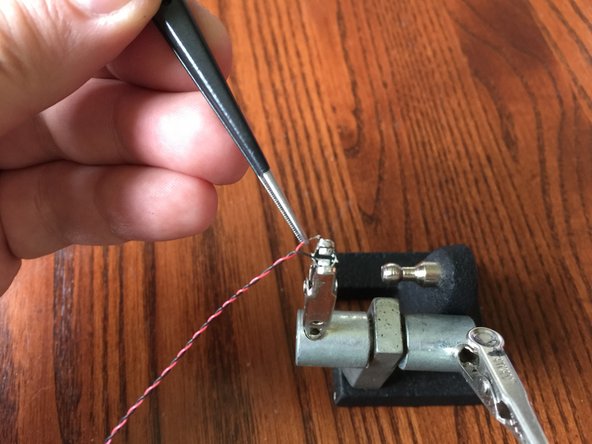 Use tweezers to hold the wire in place while soldering or re-soldering.