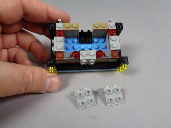 As shown in the first photo for this step, remove the two gray brackets from the front of the marquee.