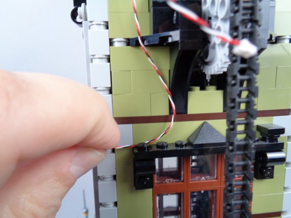 As shown in the third photo for this step, replace the pieces you removed and use these to hold the wire in place.