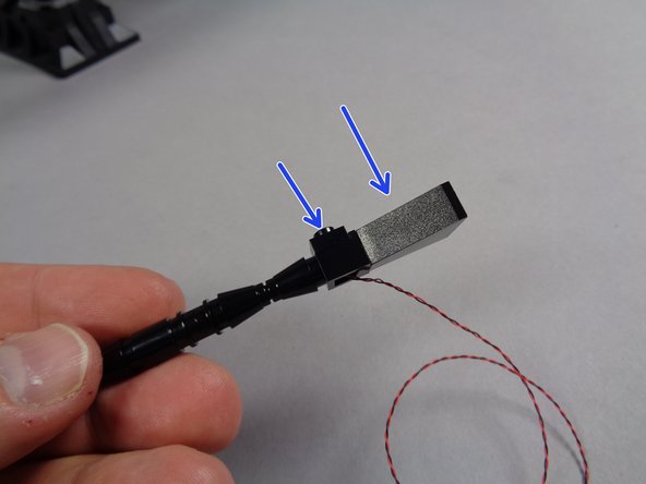 As shown by the two blue arrows in the second photo, re-attach the 1x1 black plate and the black slope to the replacement guns.  Do this for both the left and the right gun.